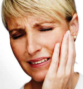 Woman holding her jaw from TMJ pain